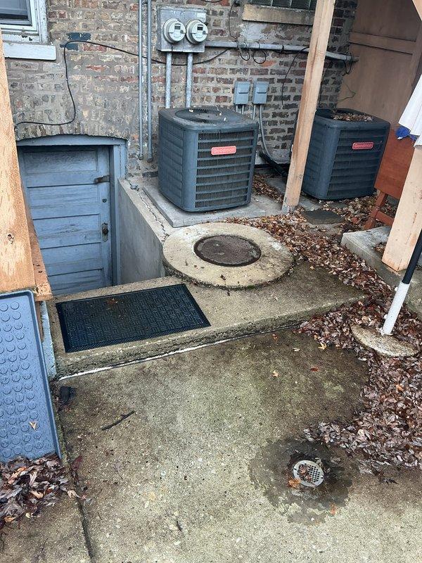 Inspected property for reported sewage odor issue persisting for several years. Identified significant corrosion and rust on vertical cast iron drain pipe in basement/crawlspace area, particularly at joint connections, which is likely the source of sewer gas infiltration. Exterior inspection revealed utility access points and drainage elements that may require further assessment.