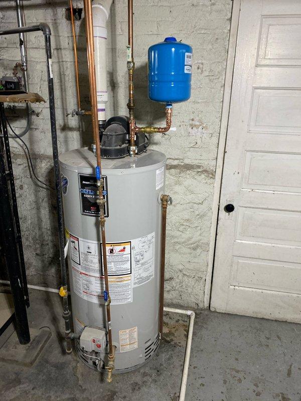 Responded to service call for leaking tanked water heater (2-3 years old). Inspection revealed minor drip from tank connection. Tightened fittings and verified proper operation of expansion tank and supply lines. Leak resolved and system now functioning normally.