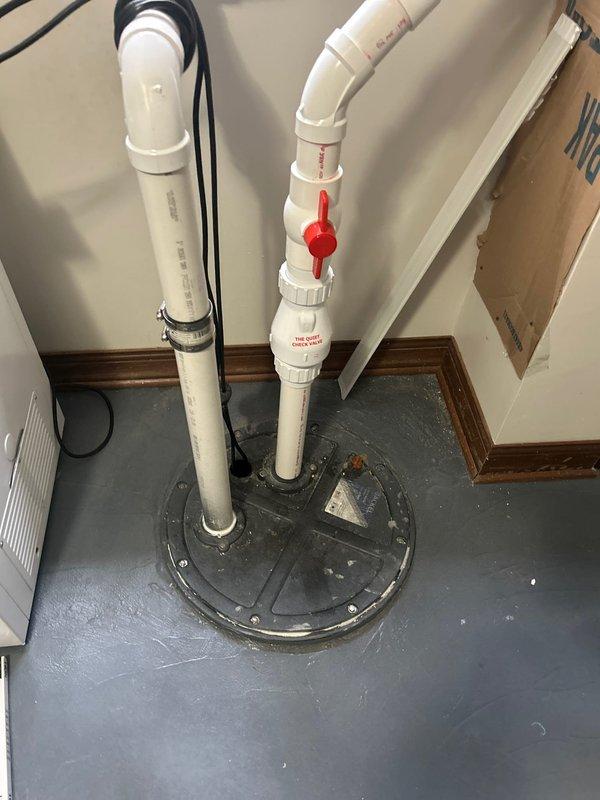 Responded to service call for ejector pump in basement cycling every 30 seconds. Inspected sump pump installation with vertical PVC discharge pipes and shut-off valve. Accessed wall cavity to examine horizontal PVC piping with connection joints, revealing the source of the frequent cycling issue.