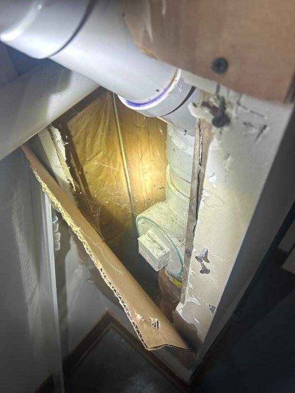 Responded to service call for ejector pump in basement cycling every 30 seconds. Inspected sump pump installation with vertical PVC discharge pipes and shut-off valve. Accessed wall cavity to examine horizontal PVC piping with connection joints, revealing the source of the frequent cycling issue.