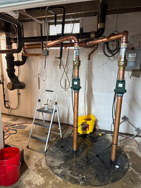 Successfully installed dual circulation pumps on copper supply lines connected to water heater system in basement utility room. Completed all necessary piping connections, ensuring proper integration with existing PVC drainage and verified system functionality before departure.