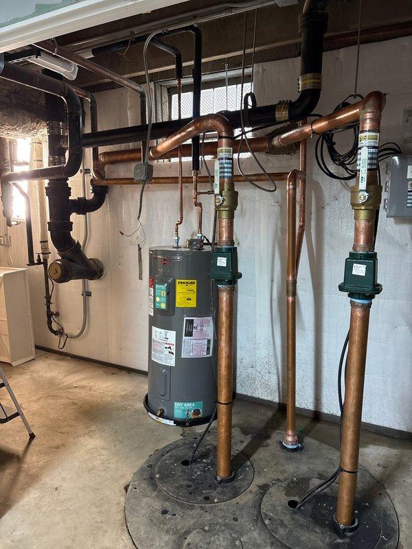 Successfully installed dual circulation pumps on copper supply lines connected to water heater system in basement utility room. Completed all necessary piping connections, ensuring proper integration with existing PVC drainage and verified system functionality before departure.