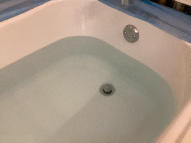 Responded to warranty service request for leaking shower and sink faucets. Discovered significant water damage to drywall near bathroom floor requiring repair, with visible deterioration and exposed interior wall material. Completed VIP maintenance service and conducted water test in bathtub to verify proper drainage and overflow functionality.