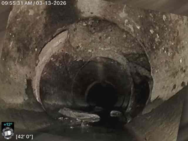 Conducted comprehensive inspection of basement utility area, focusing on water heater system with connected copper plumbing. Performed camera inspection of circular duct/pipe system, revealing significant buildup of dirt, dust and possible mold extending 42 feet with internal temperature reading of +12°. Documentation completed with timestamp photos showing condition of mechanical systems and extent of contamination requiring remediation.