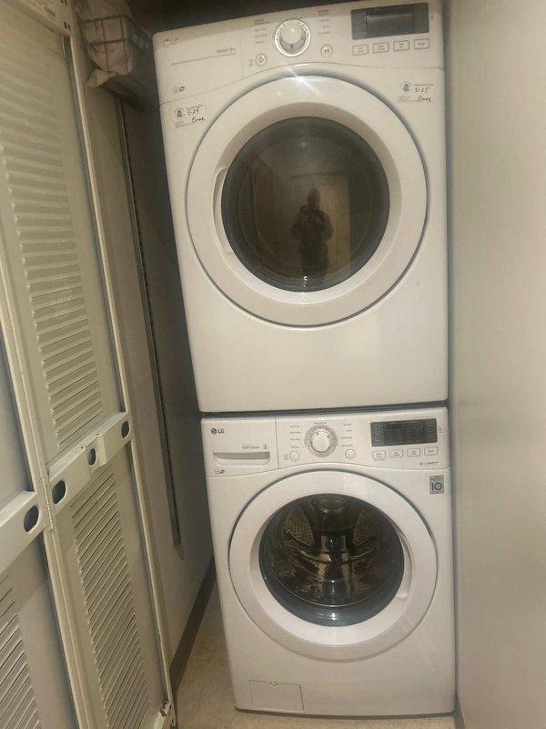 Responded to water leak service call for LG stacked washer/dryer unit. Inspected recessed utility box containing dual water supply valves with blue handles and flexible supply lines. Successfully diagnosed and repaired leak in washer supply connection, ensuring proper water flow and preventing further water damage.