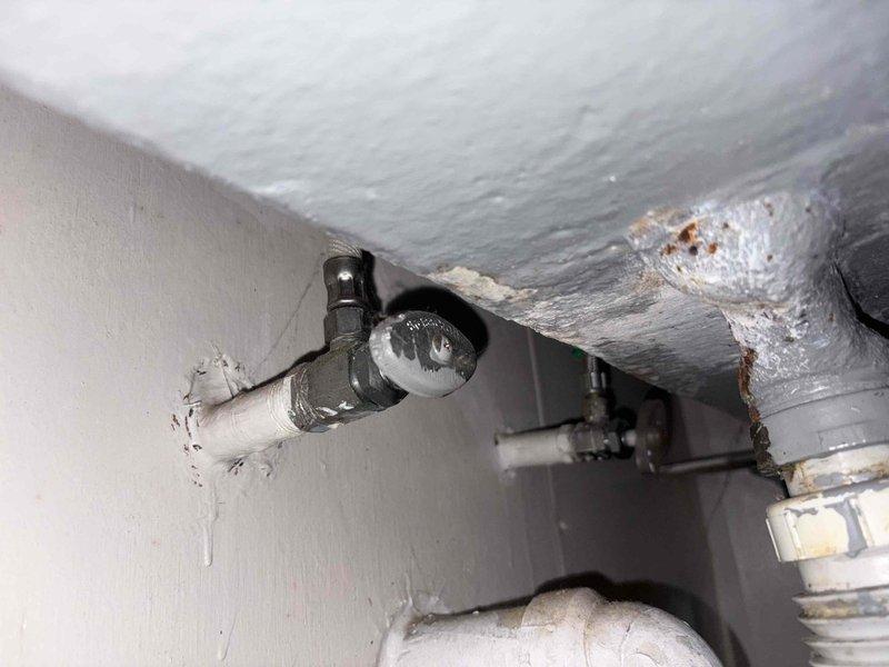 Performed assessment for potential water softener installation and hot water connection to washing machine. Inspected existing plumbing infrastructure, noting deteriorated pipe connections with visible corrosion and aging components. Documented current setup including flexible blue conduit and mounting fixtures to determine optimal integration points for requested water treatment system.