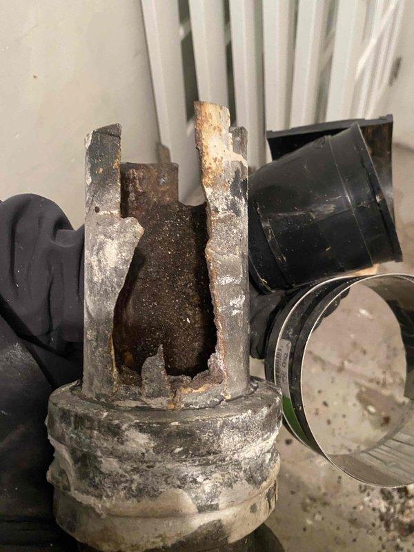 Removed severely corroded and damaged valve assembly during morning service call. Installed new PVC piping with proper elbow joint, coupling, and cleanout access point along the utility wall. System now functioning properly with no signs of leaks at connection points.