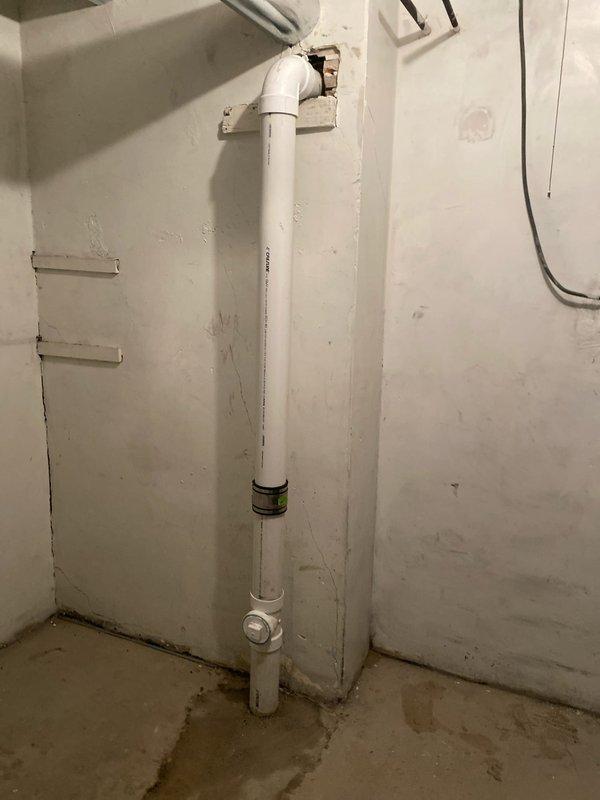 Removed severely corroded and damaged valve assembly during morning service call. Installed new PVC piping with proper elbow joint, coupling, and cleanout access point along the utility wall. System now functioning properly with no signs of leaks at connection points.