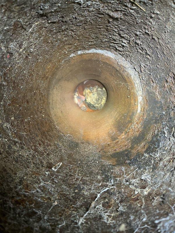 Performed camera inspection of aging downspout system. Identified significant pipe deterioration with visible corrosion and mineral buildup along interior walls. Camera revealed potential obstruction at far end of pipe, likely sediment or debris accumulation, which may be restricting proper drainage.