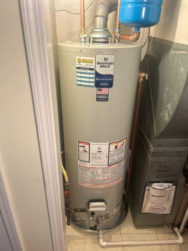 Successfully completed installation of a Bradford White residential water heater, including proper connection of copper supply lines, ventilation pipe, and installation of a blue expansion tank. All connections were verified for proper function and absence of leaks, with the system now operating at optimal efficiency.