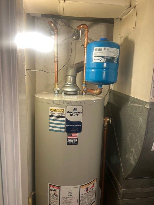 Successfully completed installation of a Bradford White residential water heater, including proper connection of copper supply lines, ventilation pipe, and installation of a blue expansion tank. All connections were verified for proper function and absence of leaks, with the system now operating at optimal efficiency.