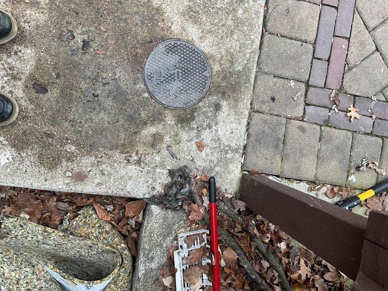 Responded to emergency call for basement flooding during heavy rain. Inspected exterior drainage system, including downspout connection and access point. Determined that washing machine drainage was backing up into basement drain due to clogged main line; cleared obstruction and verified proper system function before anticipated rainfall.
