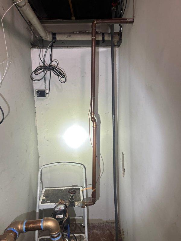 Performed site assessment for installation of automatic water shut-off valve. Inspected existing plumbing configuration in utility area, including pressure regulation assembly and copper supply lines. Evaluated optimal placement location near main water entry point where vertical copper piping connects to the distribution system.