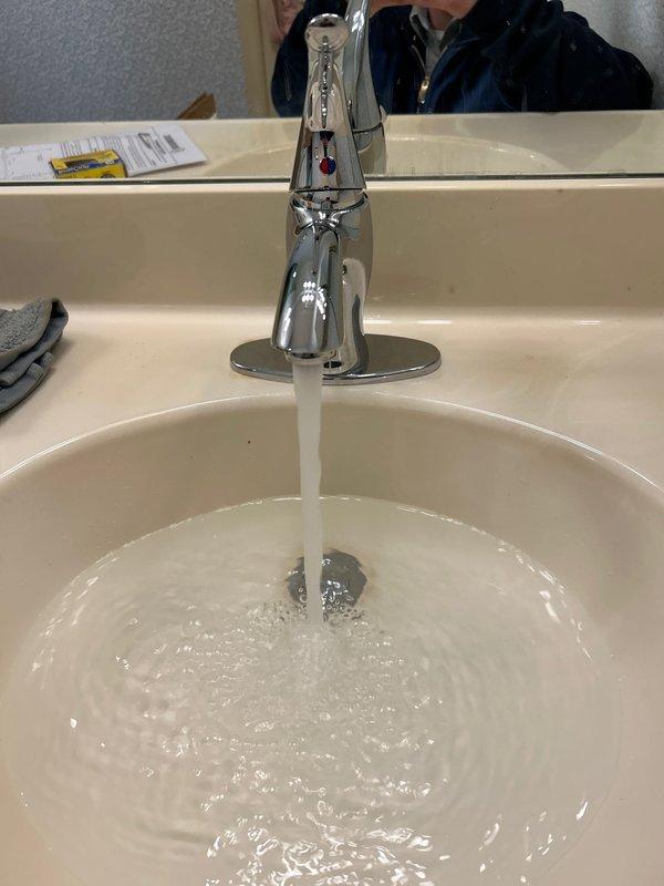 Responded to service call regarding toilet tank leaking from the back. Upon inspection, found the leak was actually originating from the bathroom sink plumbing. Examined the underside components, including PVC P-trap and supply lines with shut-off valves. Tightened loose connections and verified proper water flow and drainage. All plumbing now functioning correctly with no leaks present.