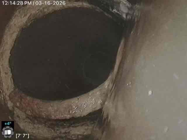 Responded to main line backup with cleanout access in basement showing signs of overflow. Utilized power auger equipment to clear significant blockage in the main drain line. Visual inspection with camera revealed extensive corrosion and oxidation at pipe junction approximately 7'7" into the line, which was likely contributing to recurring backup issues.
