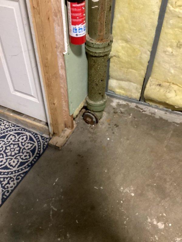 Investigated sewer odor in basement that occurs during rainfall. Inspection revealed corroded cast iron drain pipe with Y-junction showing significant aging and deterioration at connection points, likely causing sewer gas to escape. Recommended replacement of deteriorated sections and proper sealing of all pipe connections to prevent future gas leakage during weather events.