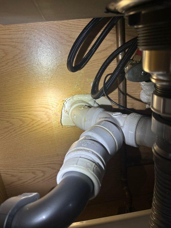 Completed installation of new sink and faucet, including proper connection of drain assembly with dual sink strainers to PVC plumbing system. Successfully installed P-trap configuration and secured all water supply lines, ensuring no leaks at connection points.