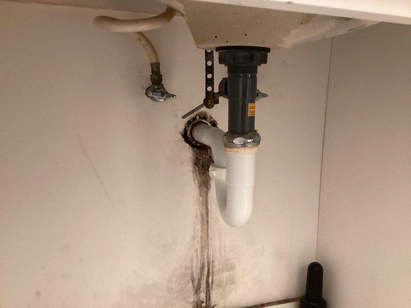 Replaced customer-supplied faucet in basement bathroom. Identified and addressed significant water damage and leakage from previous installation, evidenced by extensive staining and deterioration around the drain assembly and cabinet walls. Ensured proper connection and function of new fixture with no leaks.