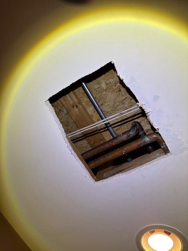 Located and repaired a pinhole leak in copper supply piping located above bedroom ceiling. Accessed plumbing through ceiling opening where significant oxidation and corrosion were observed on copper pipes. Replaced damaged section of pipe to resolve persistent slow leak.
