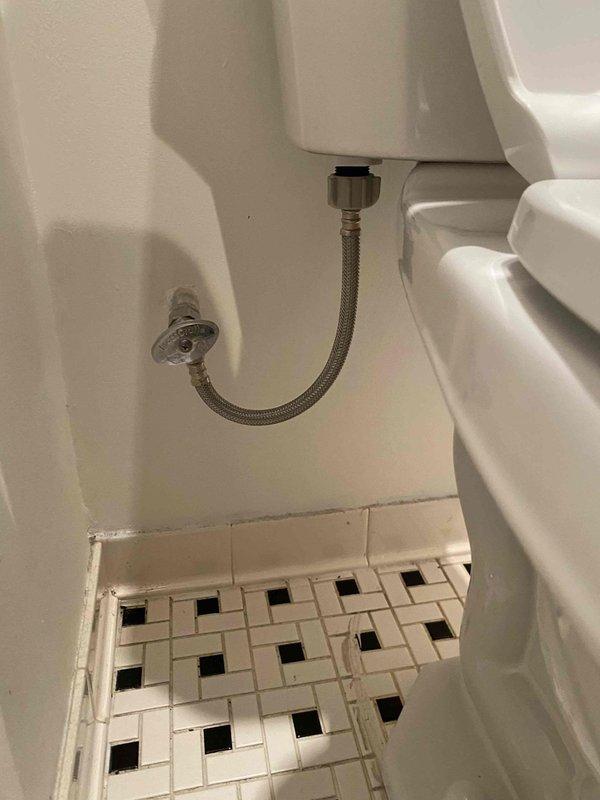 Completed installation of standard toilet fixture following building shutdown at 10:00 AM. Installed new toilet with proper connection to existing water supply line and verified functionality with no leaks at the braided stainless steel supply line or valve connections. Photos documented the completed installation showing proper mounting on decorative tile flooring and functional water connections.