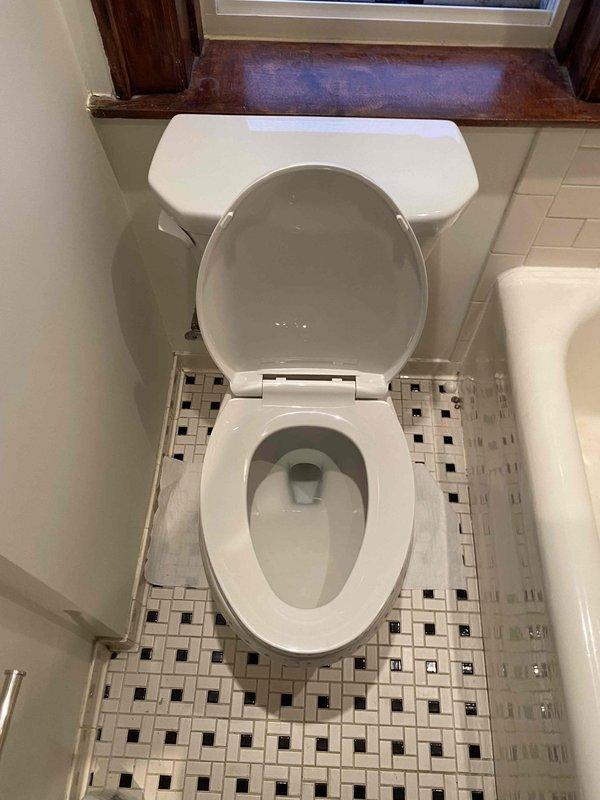 Completed installation of standard toilet fixture following building shutdown at 10:00 AM. Installed new toilet with proper connection to existing water supply line and verified functionality with no leaks at the braided stainless steel supply line or valve connections. Photos documented the completed installation showing proper mounting on decorative tile flooring and functional water connections.