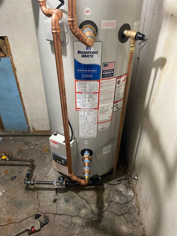 Completed installation of Bradford White water heater in utility area. Connected and properly insulated copper piping, including hot water line, and verified all connections at temperature/pressure relief valve and control unit. Installed unit is functioning properly with no leaks observed in the supply lines or at connection points.