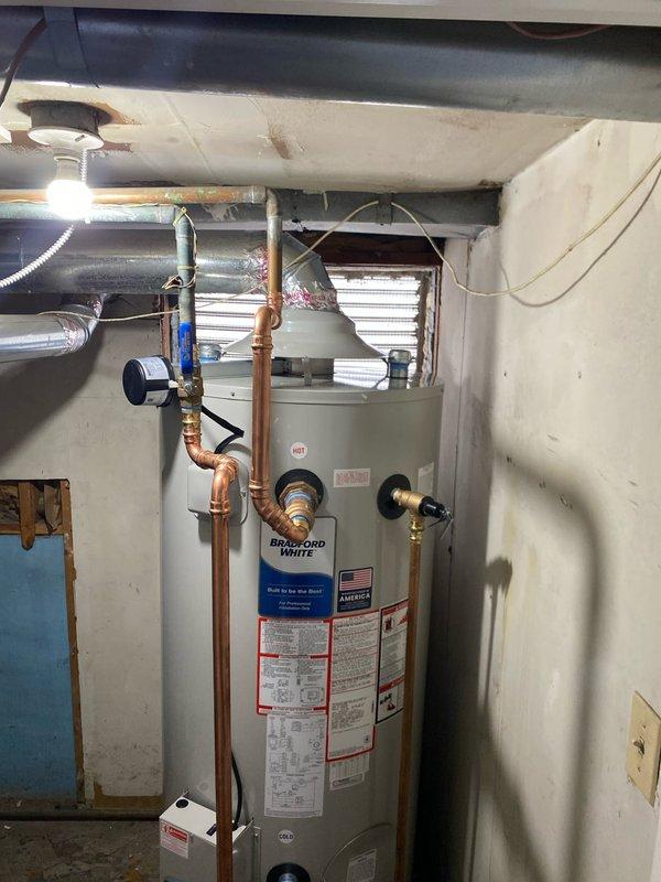 Completed installation of Bradford White water heater in utility area. Connected and properly insulated copper piping, including hot water line, and verified all connections at temperature/pressure relief valve and control unit. Installed unit is functioning properly with no leaks observed in the supply lines or at connection points.