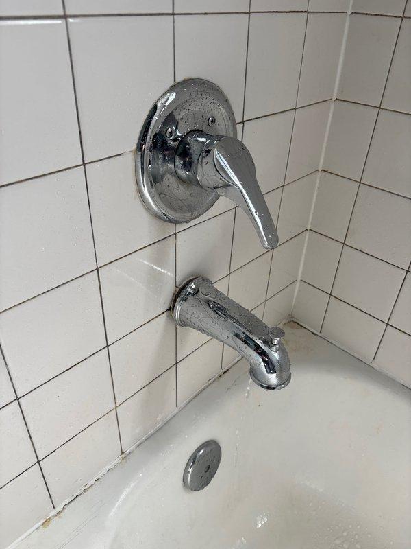 Diagnosed and repaired second floor shower exhibiting low/no water pressure and continuous water leakage from faucet when turned off. Disassembled valve assembly, removed calcium deposits and mineral buildup affecting pressure and causing diverter malfunction, then reassembled and tested to confirm proper water flow and complete shutoff.