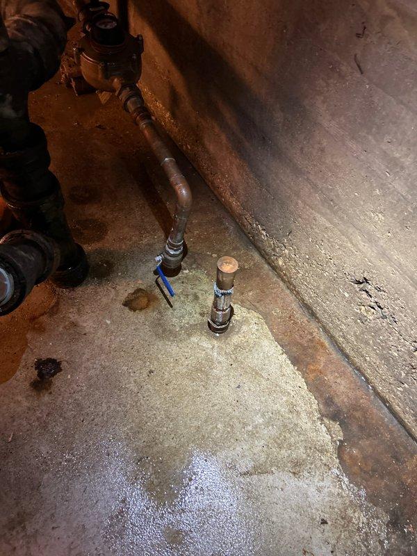 Responded to emergency main line burst at city connection point. Located significant water intrusion around copper pipe junction in basement utility area, with visible moisture on concrete floor. Repaired damaged section of main supply line and checked water meter functionality to ensure proper system operation after service completion.