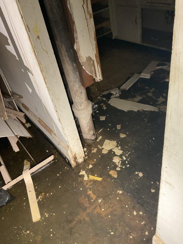Responded to priority service call for basement floor drain backup causing significant flooding. Discovered extensive water damage to basement walls, flooring, and stored construction materials. Located and evaluated the main water shut-off valve, which requires replacement to meet current code requirements.