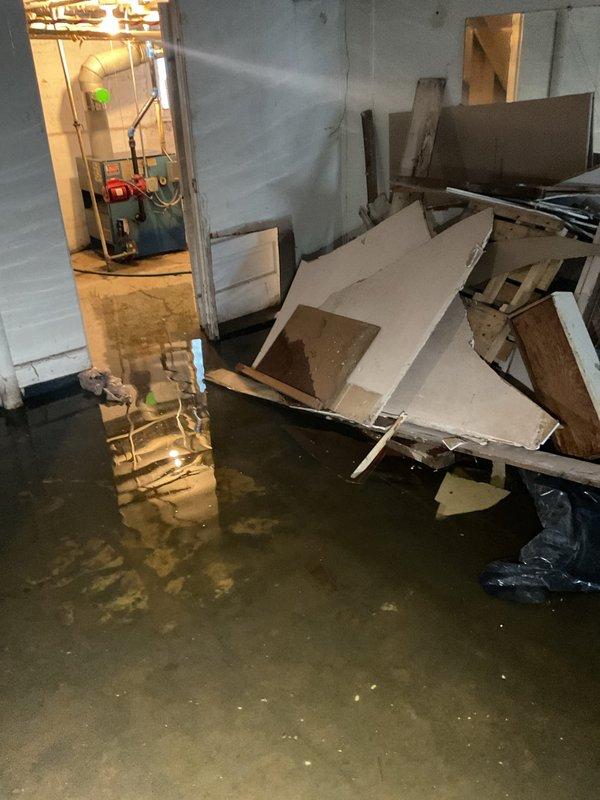 Responded to priority service call for basement floor drain backup causing significant flooding. Discovered extensive water damage to basement walls, flooring, and stored construction materials. Located and evaluated the main water shut-off valve, which requires replacement to meet current code requirements.