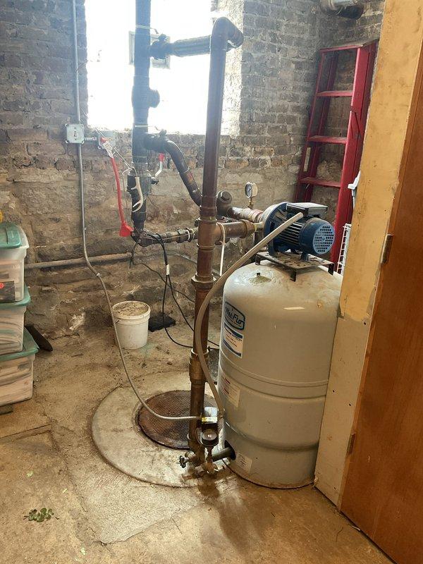 Responded to service call for dual faucet issues: diagnosed and repaired leaking shower handle that had started malfunctioning the previous day, and addressed slow leak in bathroom sink faucet. Documented condition of home's water heating system and sump pump installation with photos for service records.
