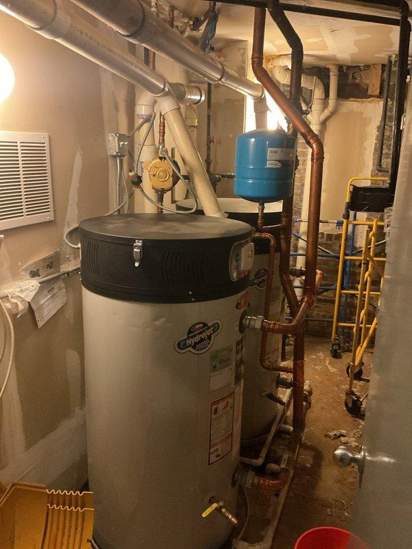 Responded to service call for dual faucet issues: diagnosed and repaired leaking shower handle that had started malfunctioning the previous day, and addressed slow leak in bathroom sink faucet. Documented condition of home's water heating system and sump pump installation with photos for service records.