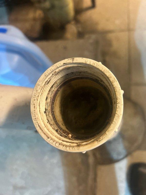 Responded to priority service call for washing machine drain backup issue in basement. Upon inspection, discovered significant buildup in the main PVC drainage pipe connecting to the washing machine discharge line. Successfully cleared the obstruction using drain cleaning equipment and verified proper drainage function with multiple test cycles.