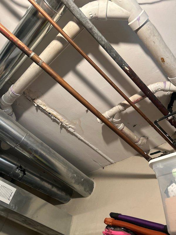 Investigated water leak in basement storage room ceiling and identified the source as a compromised joint in the PVC drainage pipe. Applied pipe sealant to the damaged joint and inspected surrounding copper supply lines for additional leakage points. Confirmed repair success with pressure testing and advised customer to monitor the affected area for 48 hours to ensure complete resolution.