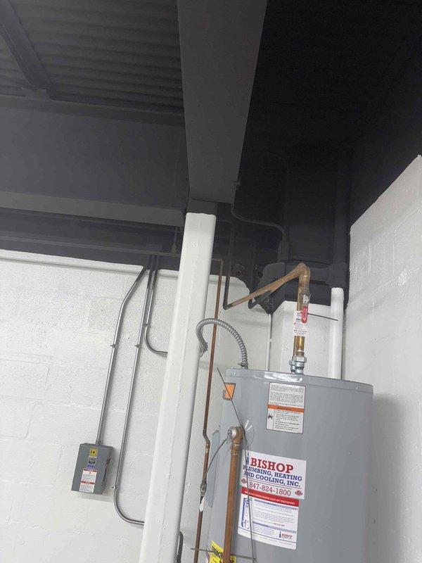 Conducted a site assessment for relocating an existing 40-50 gallon water heater. Evaluated current installation in utility area with limited space constraints, noting existing connections to copper supply lines with shutoff valve. Documented potential new location considering proper clearances, venting requirements, and accessibility for future service.