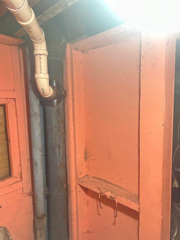 Conducted visual inspection of basement plumbing system where PVC piping connects to older metal drainage pipe via flanged fitting. Observed significant oxidation on the metal pipe section and documented potential leak point at the connection. Estimate prepared for replacement of deteriorated piping components to address active leak.