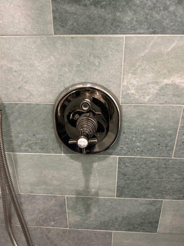 Completed installation of InSinkErator garbage disposal unit with all necessary PVC connections, P-trap assembly, and proper water supply lines. Additionally, installed shower valve control fixture with diverter component on tiled wall, ensuring secure mounting and proper alignment for optimal water flow control.