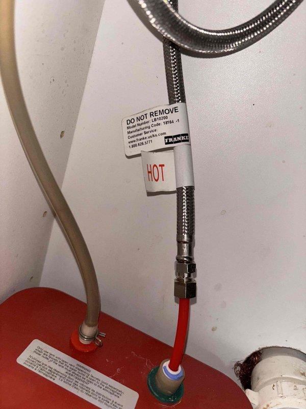 Performed sewer scope with camera inspection as part of VIP service agreement. Inspected water heater connections including hot water line and Franke-branded components. Examined toilet floor flange installation with existing wax ring, noting some corrosion on the flange and water staining on surrounding floor tiles.