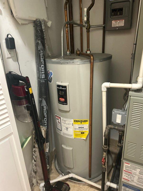 Returned for follow-up inspection of previously installed shower valve system and evaluated existing water heater for potential replacement. Confirmed proper installation and functionality of the stainless steel shower panel with multiple control buttons and rainfall shower head mounted on tiled wall. Water heater assessment completed; unit appears functional but replacement options were discussed based on age and efficiency considerations.