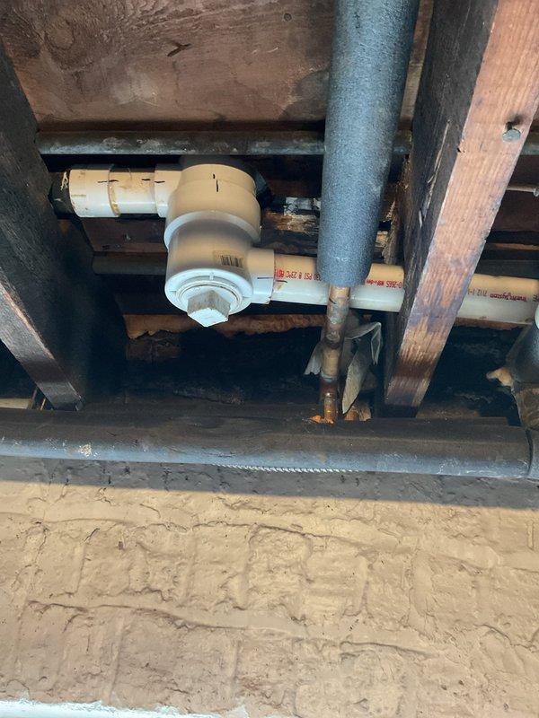 Cleared clogged bathroom tub drain by accessing the main drainage system in the crawl space. Inspected and serviced the PVC waste water lines, including the main vertical drain pipe and associated elbow joints, which revealed significant buildup causing the blockage that had resisted consumer-grade drain cleaners and manual rodding attempts.