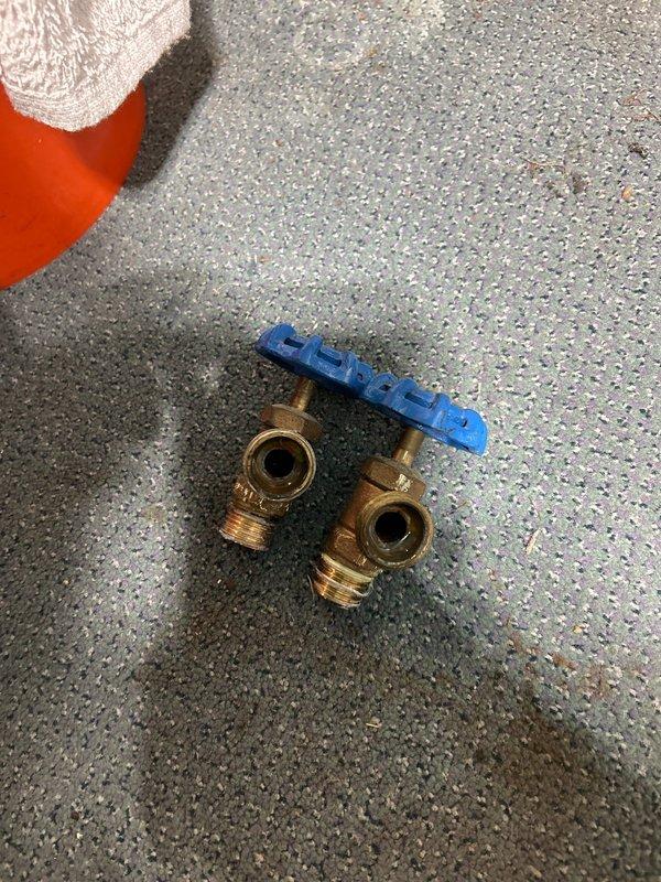 Inspected plumbing system with focus on brass fittings and water valve installation, documenting the condition of components including a water access point labeled "WATERRITE" with hot and cold connections. Noted tarnishing on brass components and verified proper function of valves after service completion.