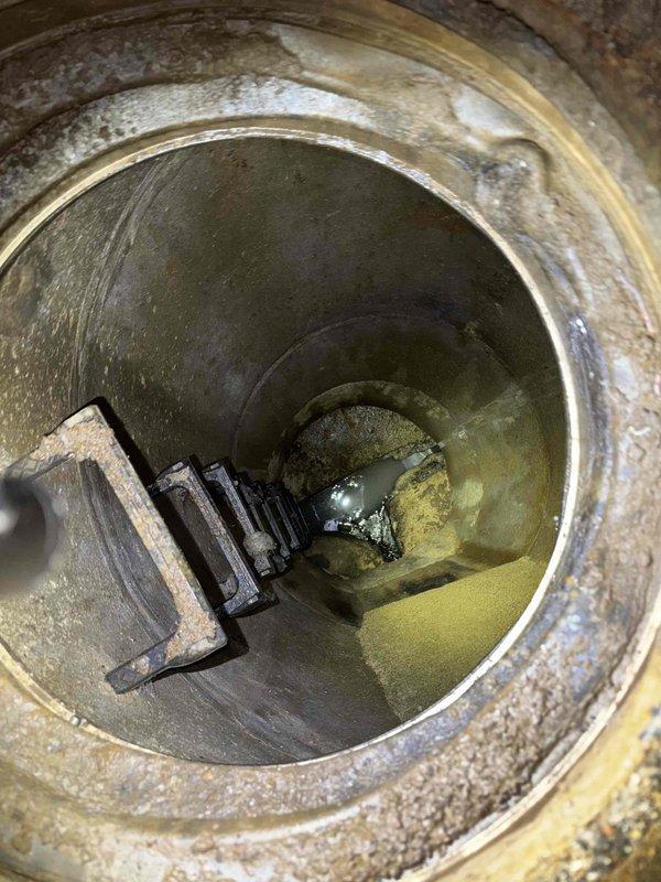 Responded to commercial facility with multiple toilets clogged and backing up through floor drain. Deployed heavy-duty drain snake/auger machine to clear severe blockage in main sewer line. Inspection of access shaft revealed significant corrosion, mineral buildup, and standing water, indicating potential need for future pipe maintenance or replacement.