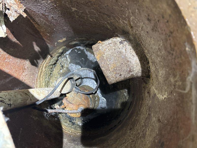 Accessed floor drain system to address deteriorated plumbing infrastructure. Inspection revealed significant corrosion and mineral buildup on pipe joints and fittings within the concrete drainage structure. Service included snaking the drain line to clear blockage and assessment of components for future replacement as scheduled.