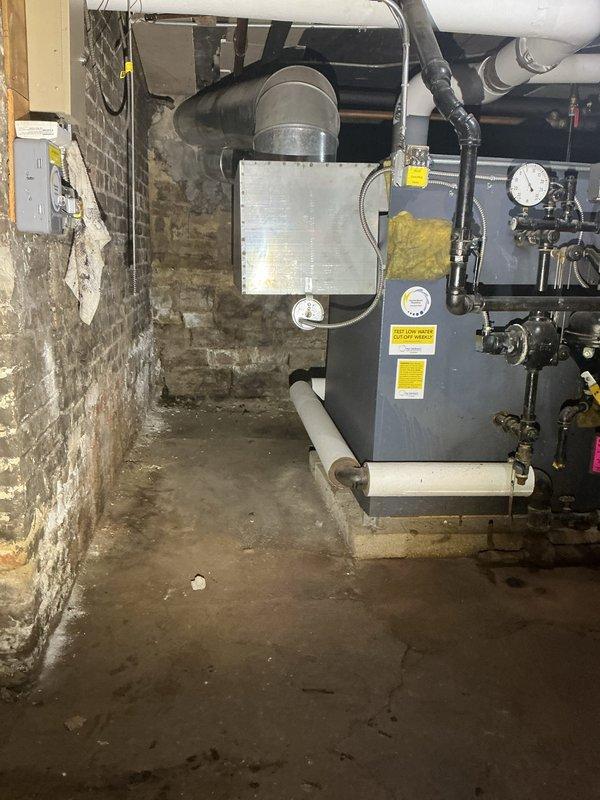 Responded to service call regarding a catch basin backup and sinkhole formation. Upon inspection, found a deteriorated catch basin with cracked walls, significant mineral buildup, and standing water containing concrete debris. Documented condition of the mechanical room infrastructure and drainage system for further assessment.