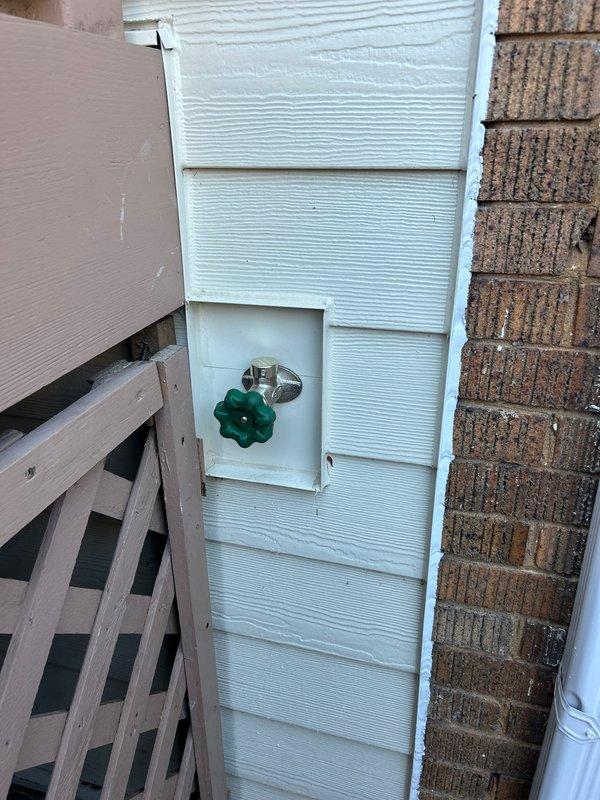 # Plumbing Service - Sold Repair Summary

Completed installation of new copper water supply lines in basement/crawl space area with connection to exterior hose bibb. Ran copper piping from interior plumbing system through foundation wall, properly securing lines along exposed brick and floor joists. Installed chrome-finished outdoor spigot with cross-handle shutoff valve on exterior white vinyl siding, ensuring proper mounting and weatherproof seal at wall penetration. All connections tested and verified leak-free with full water pressure.