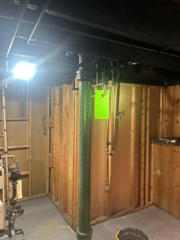 # Plumbing Estimate - DWV System Replacement

Conducted comprehensive assessment of deteriorated cast iron drain-waste-vent (DWV) system serving bathroom fixtures including tub and lavatory. Inspection revealed severely corroded cast iron branch piping with active leak at drum trap assembly. Documented extensive rust damage to horizontal waste lines and significant water damage to surrounding wooden framing members and joists, indicating prolonged moisture infiltration. 

Recommended complete removal of obsolete drum trap and replacement of compromised cast iron branch waste and vent lines with PVC piping system, properly tied into existing main stack. Scope includes opening interior wall cavity for access to affected plumbing, removal of all deteriorated piping, installation of code-compliant PVC drainage system with proper venting, and assessment of water-damaged structural framing for potential repair or reinforcement requirements.