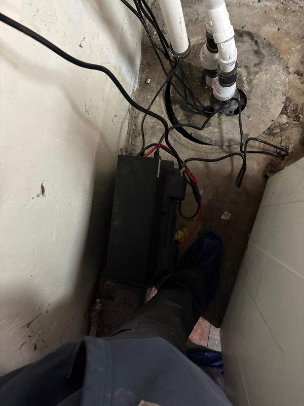 # Plumbing Estimate - Sump Pump

Responded to service call regarding malfunctioning sump pump monitoring system emitting audible alarm. Upon inspection, found dual sump pump system with electronic monitoring control unit installed in basement utility area. System was cycling between primary pump (pump 1) and secondary backup pump (pump 2) before shutting down, indicating potential float switch failure preventing proper pump activation.

Examined sump pit containing standing water with primary pump partially submerged. Assessed condition of monitoring system control box, electrical connections, and PVC discharge piping secured to wall. Observed signs of age and moisture exposure in mechanical room environment. Also noted corroded metal plumbing connections in adjacent bathroom area that may require future attention. Provided estimate for float switch replacement and system testing to restore proper sump pump operation and eliminate false alarm condition.