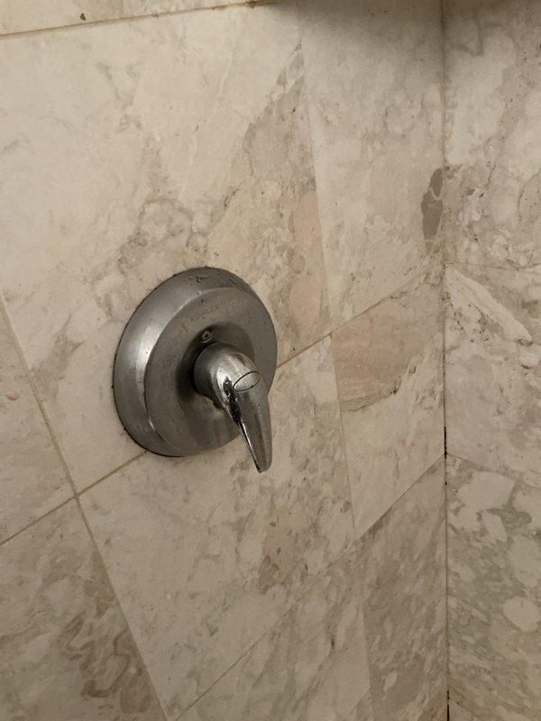 # Service Report: Shower Head Leak Repair

Responded to service call for leaky shower head in morning hours. Upon inspection, identified water leak at shower valve assembly with chrome single-handle fixture. Assessed surrounding tile work which showed evidence of prolonged moisture exposure and potential water damage behind wall surface. 

Disassembled shower trim and handle to access cartridge assembly. Replaced worn internal components including O-rings and cartridge seals that were causing the leak. Tested valve operation and verified proper hot/cold water mixing and flow control. Confirmed complete leak elimination at fixture connection points.

Inspected related plumbing infrastructure in utility area, including water supply lines, shut-off valves, pressure regulation system, and water heater connections to ensure no additional leaks or pressure issues contributing to fixture failure. All supply systems found operating within normal parameters. Reassembled shower trim and restored