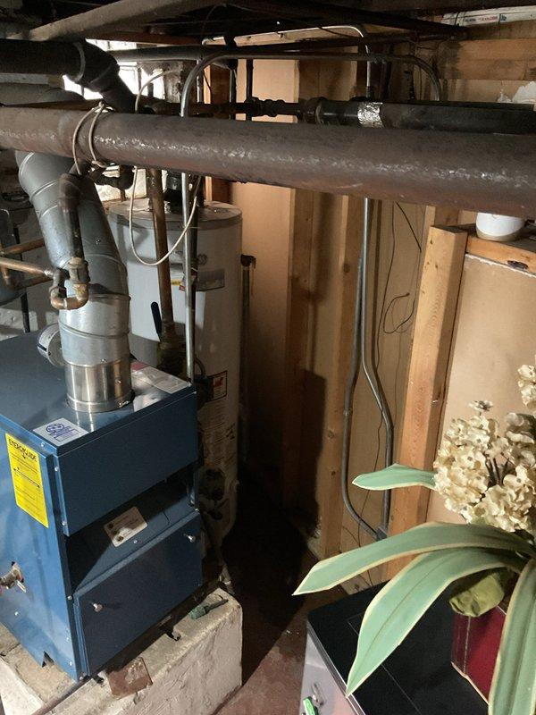 # Tanked Water Heater Service Report

Responded to service call for leaking residential hot water heater in basement utility area. Upon arrival, performed visual inspection of GE-branded tank water heater and surrounding plumbing connections. Identified active leak source and assessed water heater condition, age, and operational status. Examined inlet and outlet connections, temperature and pressure relief valve, drain valve, and gas supply line for signs of failure or deterioration. Documented equipment condition and leak location through photographic evidence showing water heater installation, associated piping, and mechanical system layout. Provided customer with diagnostic findings and recommended repair or replacement options based on severity of leak and overall unit condition.